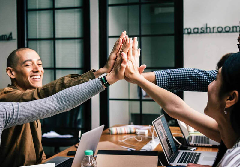 4 professionals giving high five